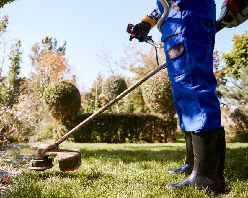 Lawn care technician using field service software in Austin to manage jobs and scheduling