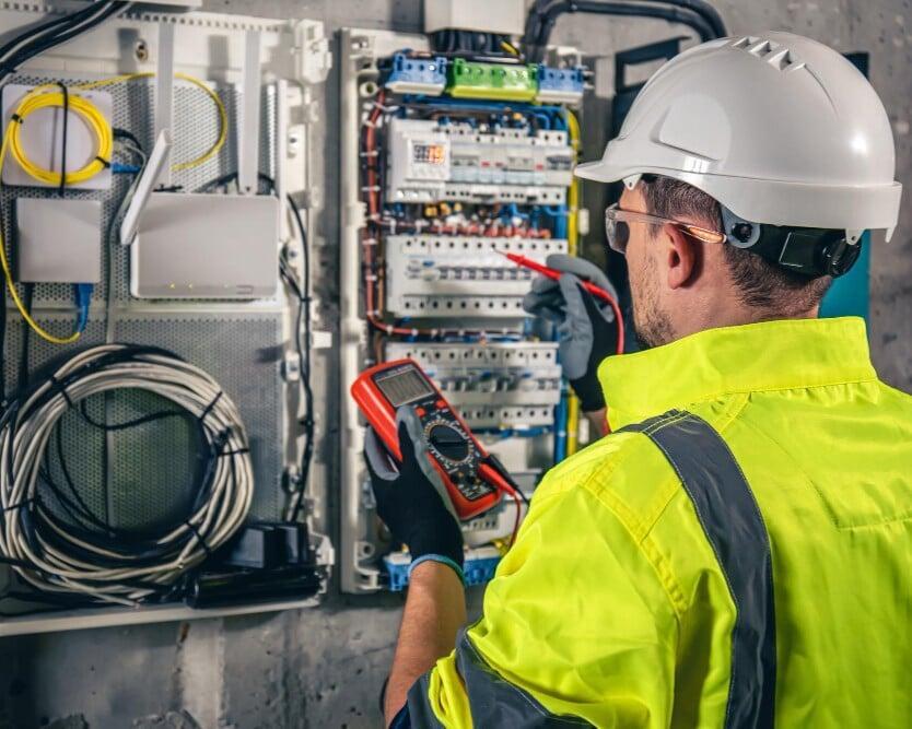 Electrician working on-site using field service management software for job tracking and invoicing in Brooklyn