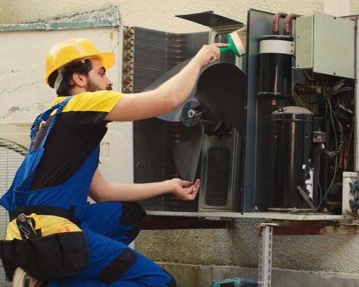 HVAC technician adjusting equipment using mobile field service software in Sacramento