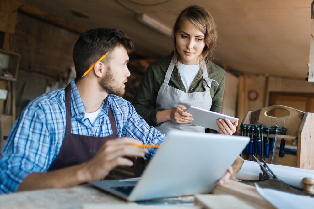 Technician using field service software on a tablet to manage small business jobs and scheduling
