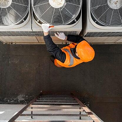 HVAC technician servicing AC unit using field service CRM to track jobs and automate dispatching